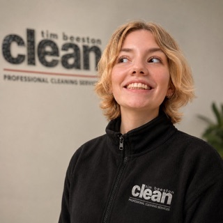 Molly smiling in her Tim Beeston Clean fleece, in front of the company logo
